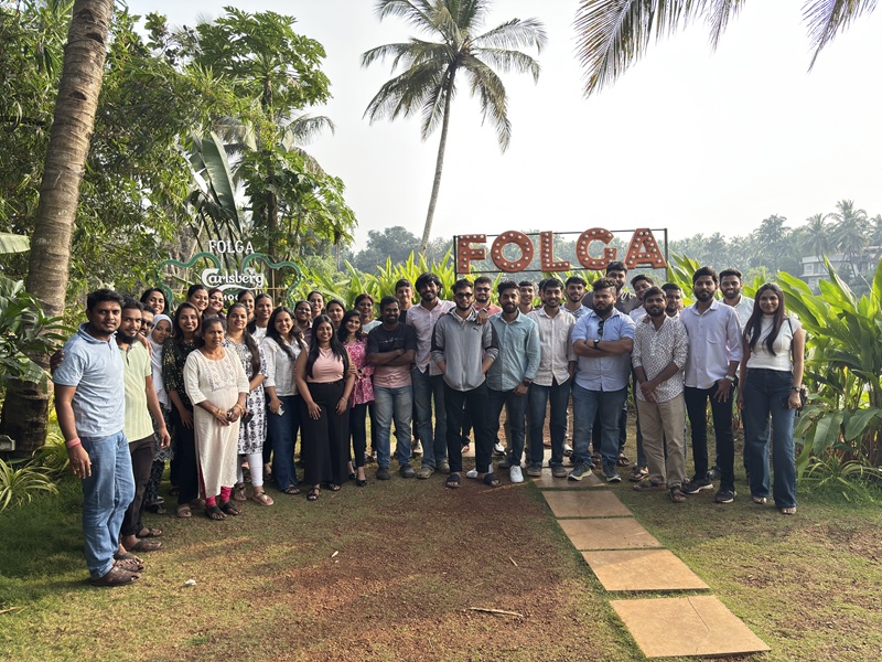 CodeMax team group photo at a Folca outdoor team lunch surrounded by Goa palm trees